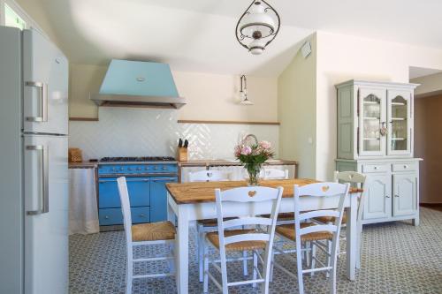 - une cuisine avec une table en bois et des chaises blanches dans l'établissement Gîte nature avec piscine privée, à Montagnac