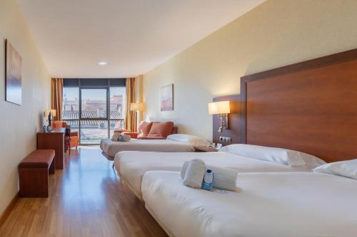 a hotel room with two beds and a couch at Moon Dreams Calabahía in Cala del Moral