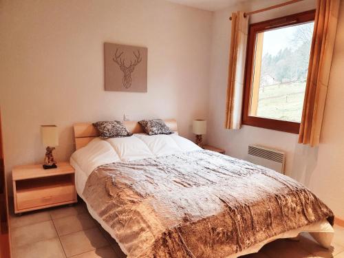 une chambre avec un lit et une fenêtre dans l'établissement Le Murmure du Ruisseau, à Xonrupt-Longemer