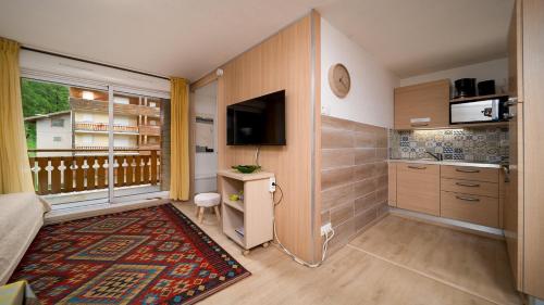 une petite chambre avec un balcon avec une télévision et une pièce dans l'établissement C DU VERDON -2301- Appt 4-6 Pers, à La Foux