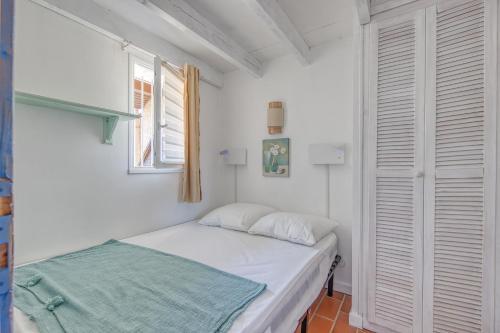 una piccola camera da letto con un letto e una finestra di Appartement Soulac a Soulac-sur-Mer