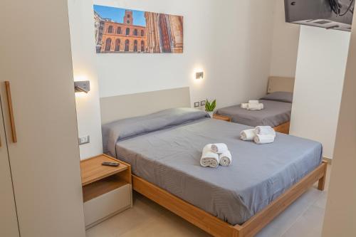a bedroom with two beds with towels on them at Isgrò Rooms in Marsala