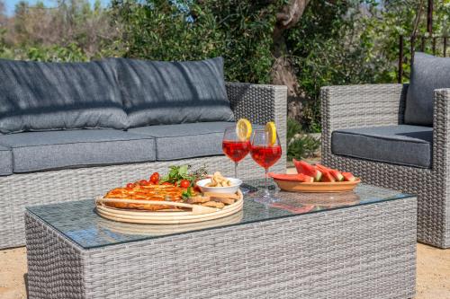 a table with a plate of food and two glasses of wine at Trullo Contessina in Torre Vado
