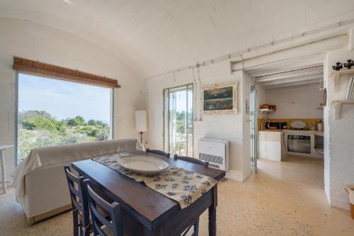 a living room with a table and a couch at Trullo Contessina in Torre Vado