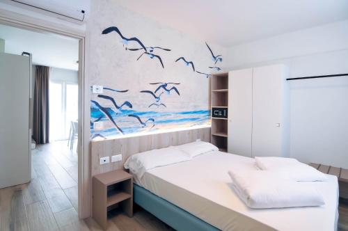 a bedroom with a bed with birds on the wall at Marina Suites & Apartments 4 stelle S in Caorle