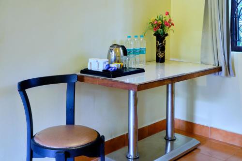 a table with a chair and flowers on it at Lifestyle villa in Candolim