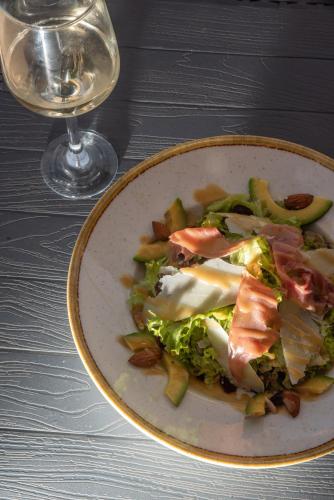 a plate of food and a glass of wine at Coralli Rooms & Restaurant in Elafonisos