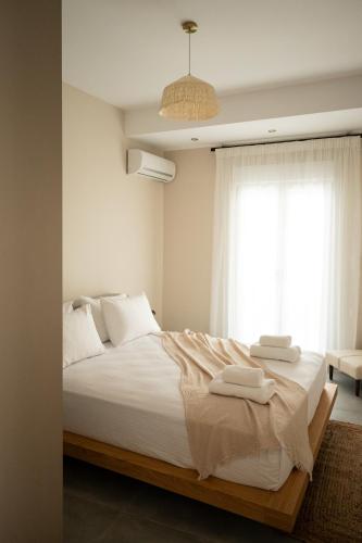 a bedroom with a large white bed with towels on it at L Horizon Luxury Living with Sea View by 8essentially in Heraklio