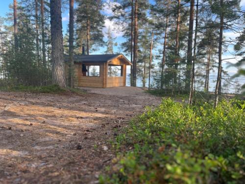 a small wooden cabin in the middle of a forest at KoloCabins - Huuhanranta 5 in Ruokolahti