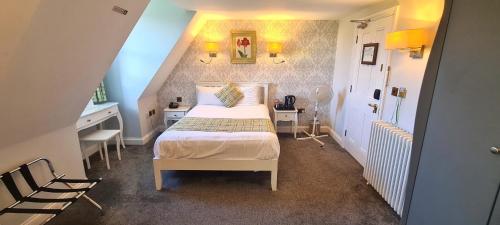 a bedroom with a bed and a desk and a staircase at Shendish Manor Hotel & Golf Course in Hemel Hempstead