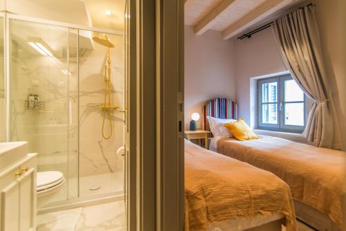 a bathroom with two beds and a glass shower at The Melegran in Rovinj