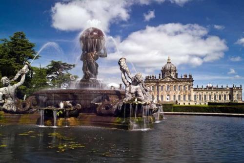 a fountain in the water in front of a building at Luxury Barn with sauna near York welcoming families, friends, groups in York