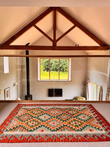 a large rug on the floor in a room with a window at Luxury Barn with sauna near York welcoming families, friends, groups in York