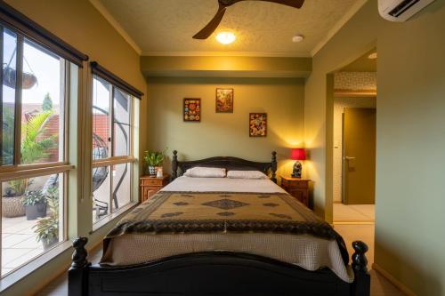 ein Schlafzimmer mit einem Bett und einem großen Fenster in der Unterkunft Lily Lakes - Resort Style Living in Cairns