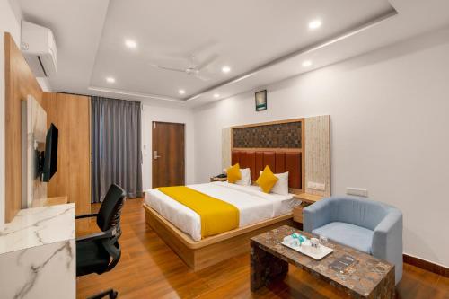 a hotel room with a bed and a chair at Gateway Inn in Bangalore