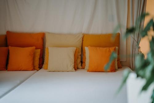 a bed with orange and white pillows on it at Hotel Adria in Merano