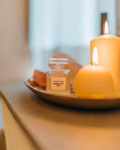 a plate with two candles on a table at La Monastica Resort & Spa in Borgo a Buggiano