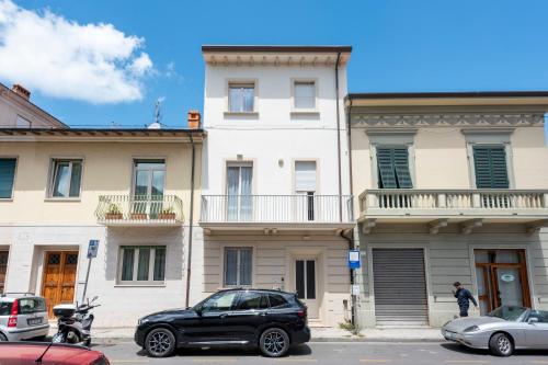 a black car parked in front of a building at La Suite 2 Ondina Viareggio 200m from sea - Happy Rentals in Viareggio