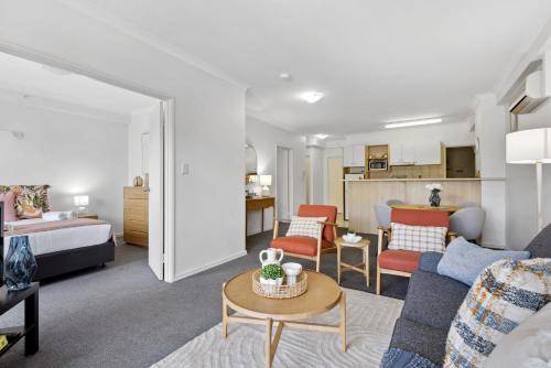 a living room with a couch and a bed at Cozy City Apartment with Stunning Views and Ameni in Perth