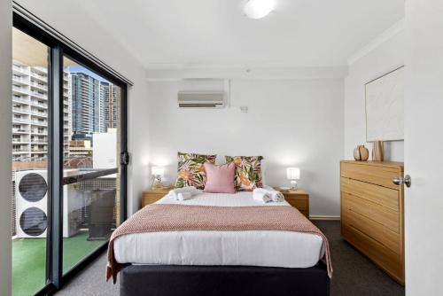 a bedroom with a large bed and a large window at Cozy City Apartment with Stunning Views and Ameni in Perth