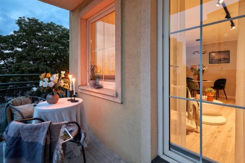 a balcony with a table with a candle and a window at Amber Premium Apartments in Bydgoszcz