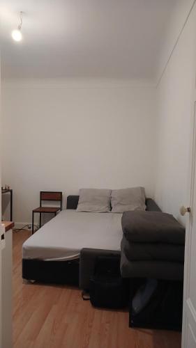 une chambre avec un lit et un canapé dans l'établissement Joli Cocon Boulogne Billancourt, à Boulogne-Billancourt