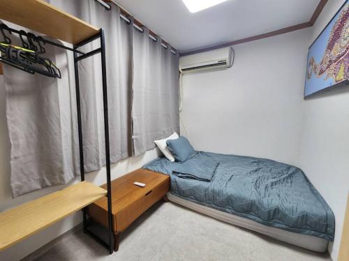 une petite chambre avec un lit et une fenêtre dans l'établissement stc 1, à Séoul