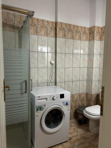 a washing machine in a bathroom with a toilet at Sofi's Seaside in Ofrínion