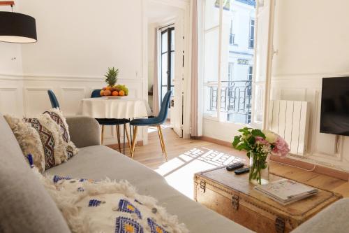salon z kanapą i stołem w obiekcie Le Marais cosy-comfy appartment w Paryżu
