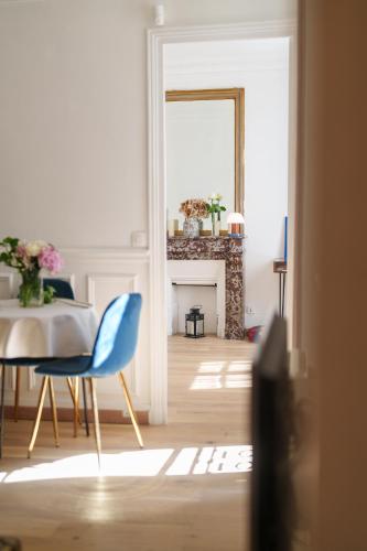 un salon avec une chaise bleue et un miroir dans l'établissement Le Marais cosy-comfy appartment, à Paris