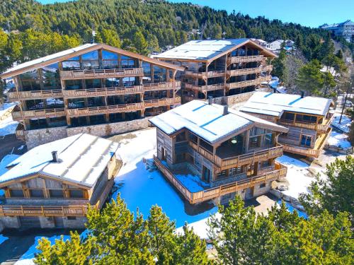 - une vue aérienne sur un complexe avec des bâtiments recouverts de neige dans l'établissement Appartements Collection Cassiopée - Les Chalets Secrets, à Font-Romeu