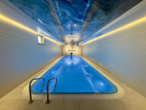 a indoor swimming pool with a blue ceiling at Hotel Sultan in Qarshi