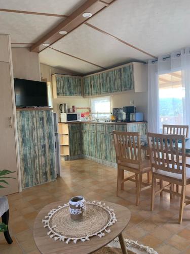 un salon avec une table et des chaises et une cuisine dans l'établissement résidence de vacances soleiluna, à Rocbaron