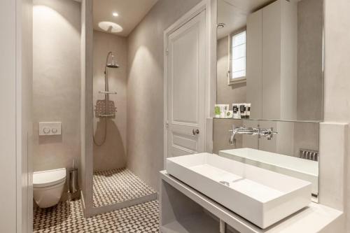 une salle de bain avec un lavabo et des toilettes dans l'établissement Sublime Appartement de Charme, à Paris