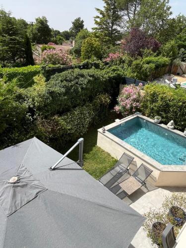 un parasol et des chaises à côté d'une piscine dans l'établissement Villa piscine plein sud proche Uzes, à Arpaillargues-et-Aureillac