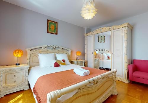 a bedroom with a large bed and a pink chair at Stunning House 5-Bedrooms for 9P- 20min from Paris in Le Blanc-Mesnil