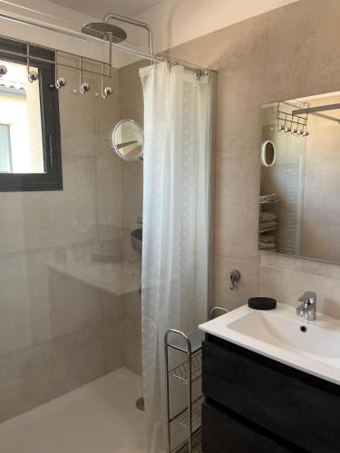 une salle de bain avec un rideau de douche et un lavabo dans l'établissement Villa piscine plein sud proche Uzes, à Arpaillargues-et-Aureillac