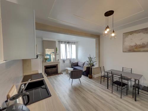 une cuisine et un salon avec une table et des chaises dans l'établissement Maison Cosy à Saint-Dizier, à Saint-Dizier