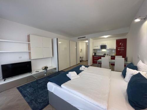a bedroom with a large white bed and a kitchen at Smart Hotel Budapest in Budapest