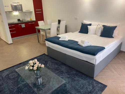 a bedroom with a bed with a table and a kitchen at Smart Hotel Budapest in Budapest