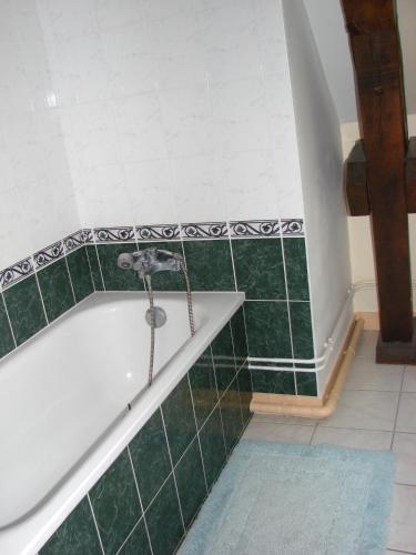 La salle de bains est pourvue d'une baignoire avec du carrelage vert. dans l'établissement Gîte de l'Orangerie, 15 personnes, 7 ch, 275 m², à Saint-Gervais-la-Forêt