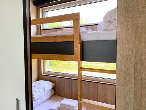 a bunk bed in a small room with a window at Arche Siedlisko Miedwieżyki in Milejczyce