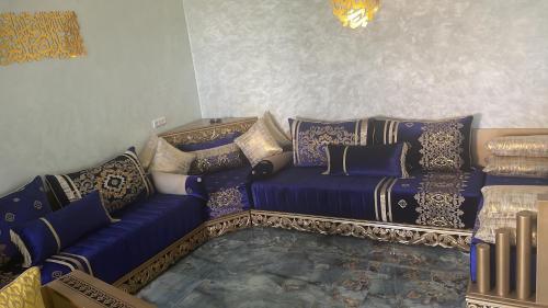 a living room with a blue couch with pillows at Villa vue mere 3 chambre et 2 salon salle de fetes in Kenitra