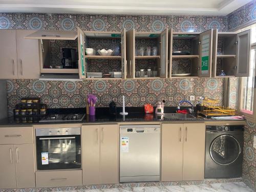 a kitchen with a stove and a dishwasher at Villa vue mere 3 chambre et 2 salon salle de fetes in Kenitra