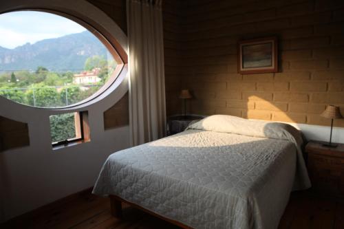 Madre Tierra B&B في تيبوزتلان: غرفة نوم بسرير ونافذة كبيرة