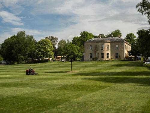 an old house on a large grassy field at Bishopstrow Hotel and Spa - Small Luxury Hotels of the World in Warminster