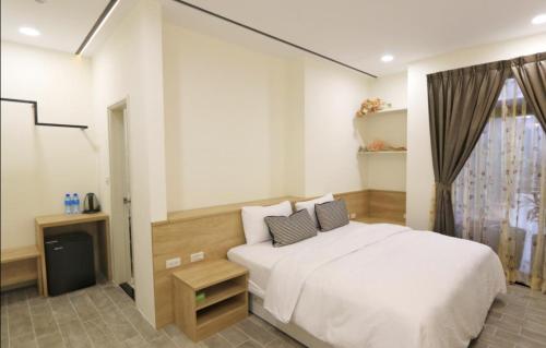 a bedroom with a white bed and a window at Wangan 175 B&B in Shui-wa-chüeh