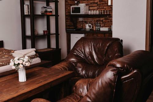 a living room with a leather couch and a table at BUBLA CITY RANCH in Kopřivnice