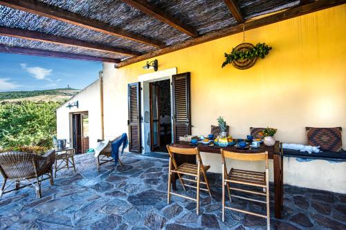 a patio with a table and chairs and a building at Baddi Di La Predda - Happy Rentals in Sassari