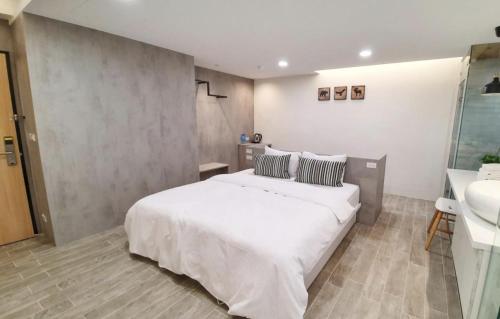 a bedroom with a large white bed and a sink at Wangan 175 B&B in Shui-wa-chüeh